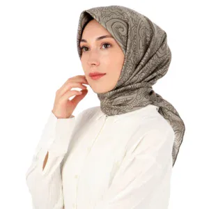 Elegant woman wearing a patterned silk hijab and white blouse, showcasing traditional Turkish fashion with modern style. Perfect for cultural and fashion enthusiasts.