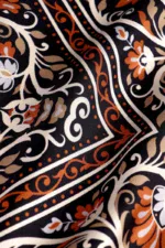 Elegant traditional Turkish patterned fabric with floral and geometric motifs in black, white, and orange hues, showcasing high-quality craftsmanship from Turkey.