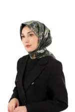 Stylish woman wearing a patterned silk hijab and a black blazer, showcasing Turkish fashion and accessories for women, on a white background.