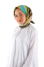 Elegant woman wearing a colorful silk headscarf, white blouse, and minimal makeup, showcasing Turkish fashion and accessories for a stylish and cultural look.
