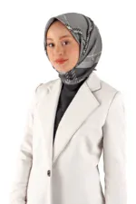 Modern woman wearing a stylish gray silk hijab and elegant white blazer, promoting fashion accessories and modest clothing from Turkey’s Shop of Turkey collection.