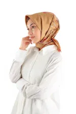 Elegant woman wearing a beige satin hijab with floral patterns and a white textured shirt, representing modest fashion and Turkish cultural apparel.