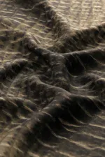 Luxurious black and beige patterned fabric with a smooth, silky texture, draped to showcase its fluidity and elegant design. Perfect for high-end fashion or home decor projects.