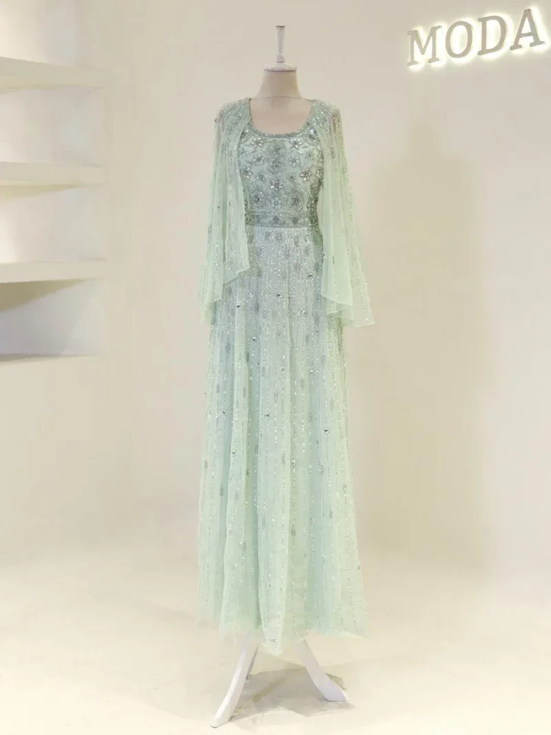Detailed, sparkling mint green dress with embroidery, sequins, and sheer fabric for an elegant look.