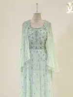 A stunning light green dress adorned with intricate silver embroidery and embellishments, featuring a matching cape for a sophisticated look. Perfect for special occasions.