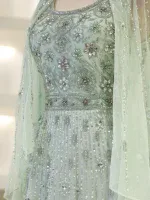 Luxurious mint-green dress with intricate silver bead and rhinestone embellishments for special occasions. Fine craftsmanship and detailed design highlight sophistication and style.