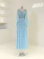 Bright, detailed image of a stunning light blue dress featuring intricate embroidery and a sheer overlay, displayed on a mannequin in a fashion boutique.