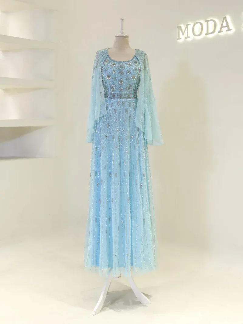 Bright, detailed image of a stunning light blue dress featuring intricate embroidery and a sheer overlay, displayed on a mannequin in a fashion boutique.