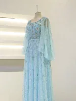 Elegant turquoise dress with intricate silver embroidery, beading, and layered chiffon sleeves, perfect for special occasions or traditional celebrations.