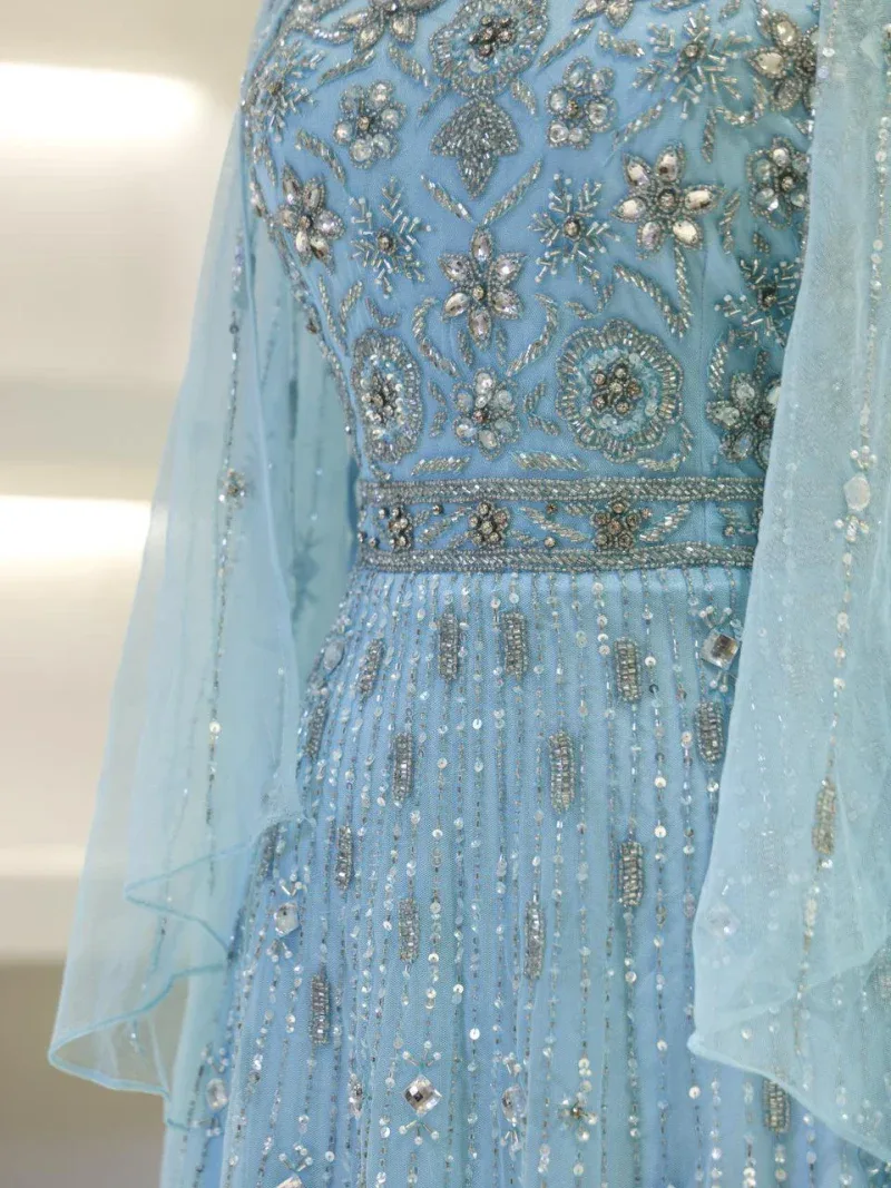 A stunning light blue dress featuring intricate embroidery, sequins, and beadwork, perfect for special occasions and celebrations. Crafted with detailed craftsmanship for a luxurious look.