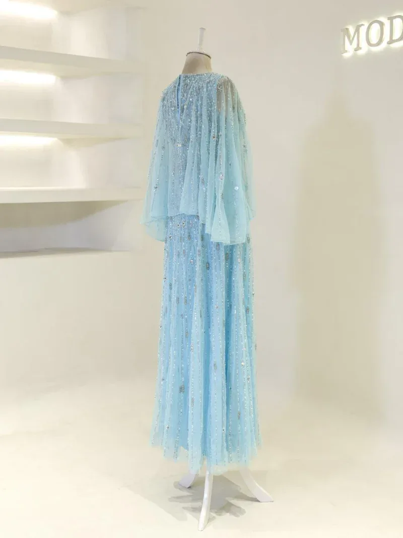 A stunning light blue dress with shimmering sequins, layered tulle fabric, and long flowing skirt, perfect for special occasions and celebrations.