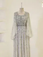 Luxurious white gown featuring intricate embroidery and beadwork, perfect for special occasions or weddings. Made with high-quality fabrics and craftsmanship for a stunning appearance.