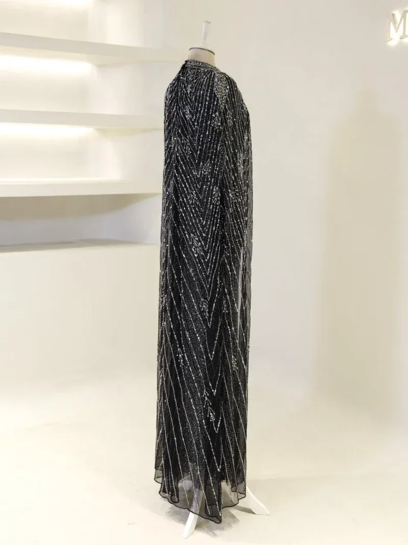 Stunning black gown adorned with sparkling sequins, perfect for glamorous events and parties, showcasing intricate beadwork and a long, flowing silhouette for a luxurious look.