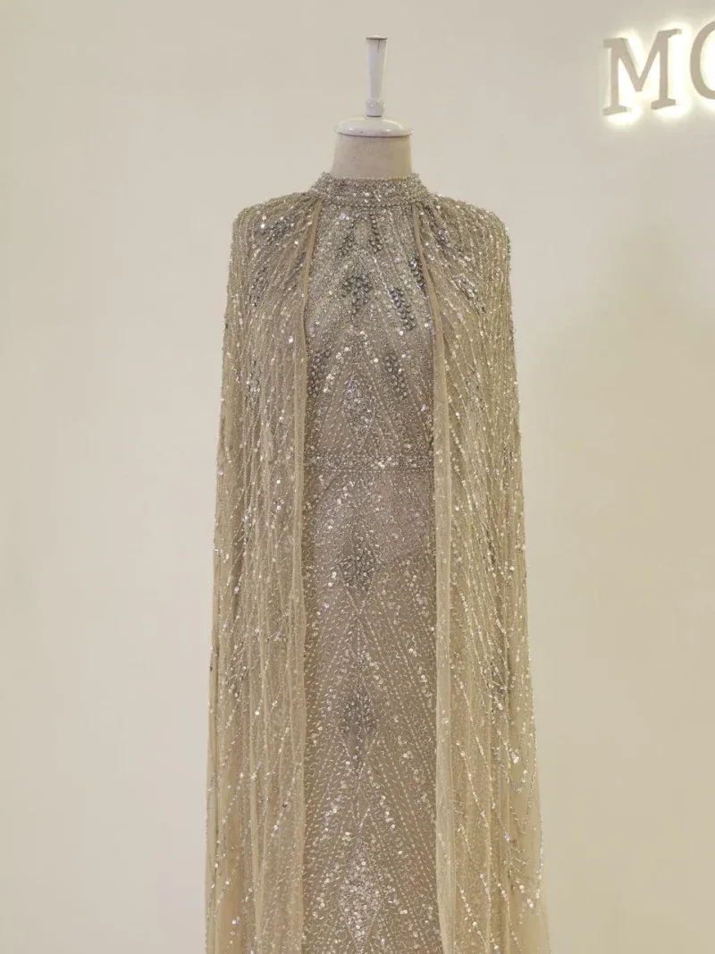 Elegant gold sequin gown with intricate beadwork and a dramatic cape, perfect for special occasions and celebrations.