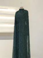 Stunning dark green beaded gown with intricate embellishments and sheer cape, perfect for formal events. Crafted with high-quality materials for a luxurious look.