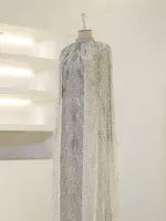 Elegant white gown with intricate beadwork and sequins, perfect for weddings or special occasions. Folded cape adds a regal touch to this stunning dress.