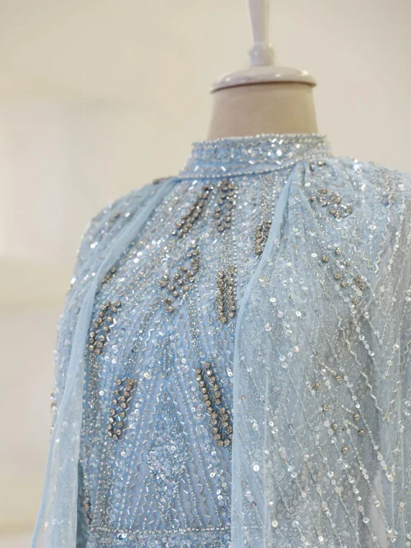 A stunning light blue dress adorned with sparkling silver sequins and embroidery, perfect for formal events or celebrations, emphasizing craftsmanship and elegance.