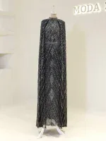 An exquisite black and silver beaded evening gown displayed on a mannequin, featuring intricate geometric patterns, shimmering embellishments, and a long flowing silhouette, ideal for formal occasions.