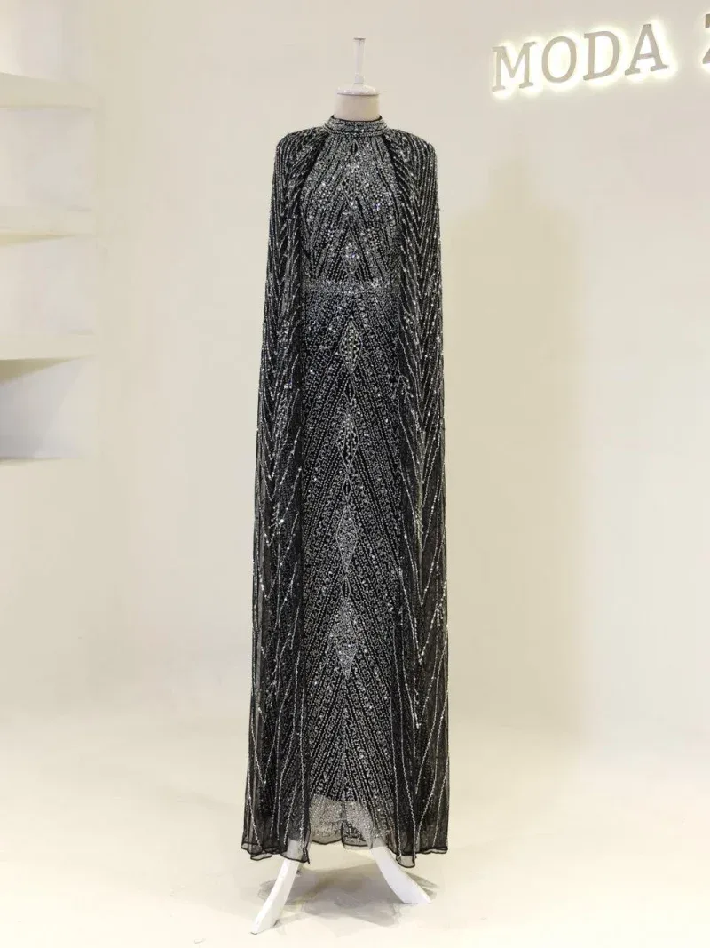 An exquisite black and silver beaded evening gown displayed on a mannequin, featuring intricate geometric patterns, shimmering embellishments, and a long flowing silhouette, ideal for formal occasions.