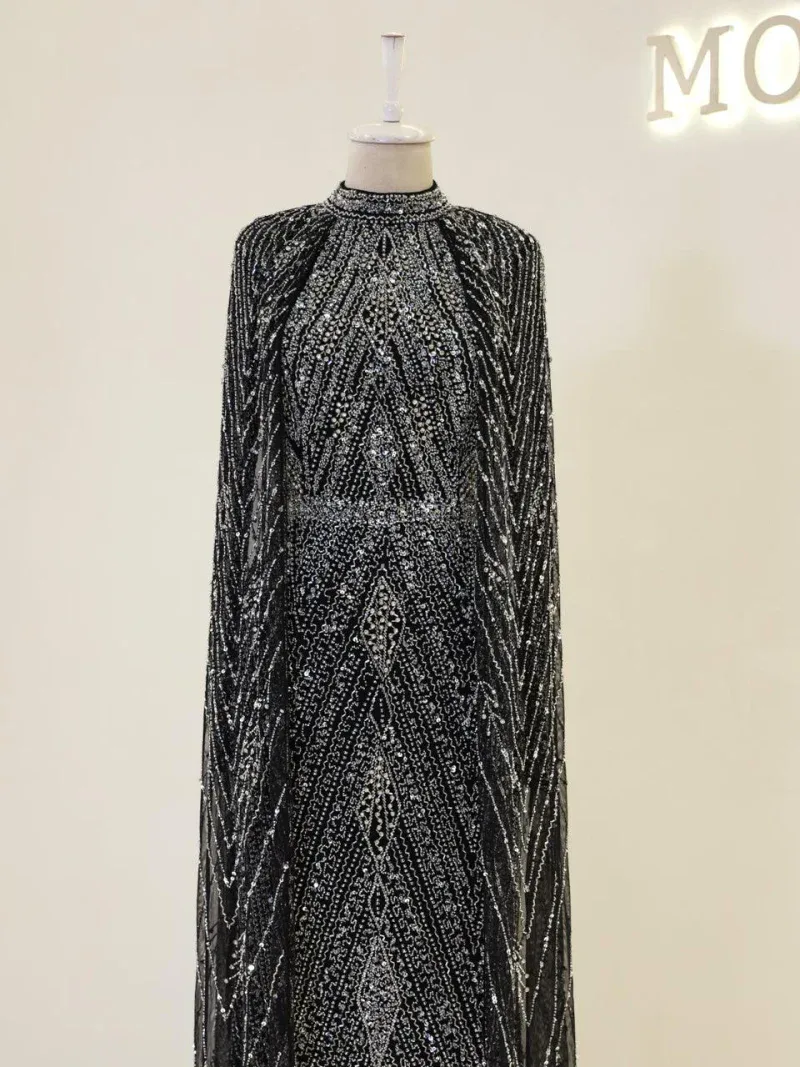 Elegant black and silver beaded evening gown with intricate patterns, high neckline, and long sleeves, perfect for formal occasions and glamorous events.