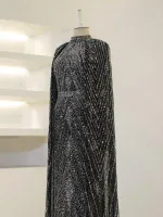 Glamorous black and silver sequin evening dress, perfect for special occasions, with intricate beaded patterns and flowing fabric for an elegant look.