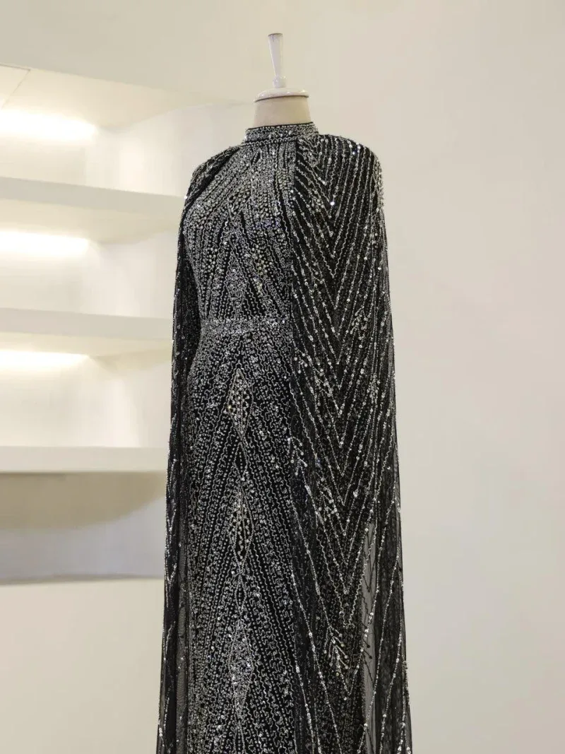 Glamorous black and silver sequin evening dress, perfect for special occasions, with intricate beaded patterns and flowing fabric for an elegant look.