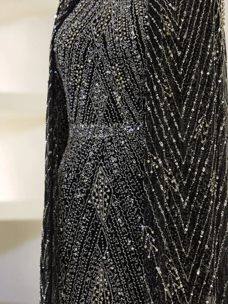 Gorgeous black dress adorned with intricate silver sequins, perfect for special occasions or evening events. Features a fitted silhouette with a shimmering, stylish design.