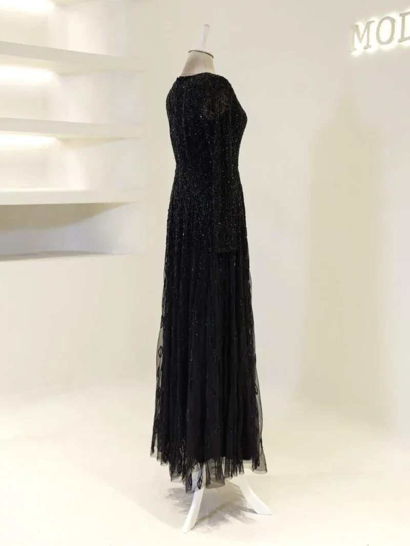 Stunning black evening dress with shimmering sequins, perfect for formal events and celebrations. Fully lined, with an elegant long flowing skirt and fitted silhouette.