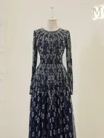 Luxurious black evening dress decorated with intricate silver embroidery and sequins, featuring a long fitted silhouette with sheer long sleeves and a flowing skirt, perfect for formal occasions.