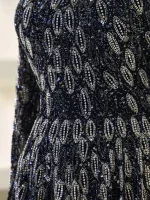 A stunning black dress adorned with intricate silver beadwork creating a luxurious and eye-catching pattern perfect for evening wear and special occasions.