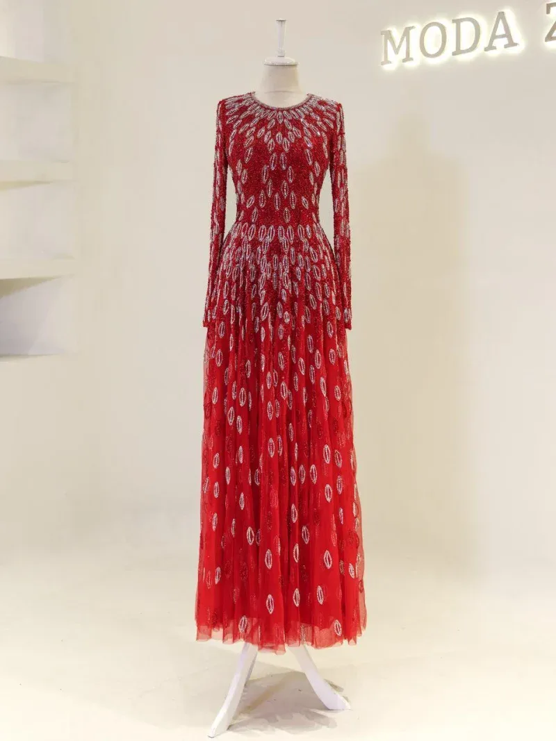 Vibrant red dress featuring exquisite embroidery with silver accents, long sleeves, and a flowing maxi length, displayed on a mannequin. Ideal for those seeking unique, high-end attire with fast shipping from Turkey.