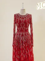 Gorgeous red evening gown with intricate silver beadwork, long sleeves, and a flowing skirt perfect for special occasions and formal events.
