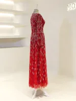 Stunning red dress adorned with silver leaf patterns, featuring a flowing floor-length design and sleeveless cut, ideal for sophisticated evening wear.