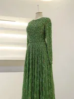 Stunning long green dress adorned with shimmering sequins, perfect for special occasions or evening events. Features intricate detailing and a flowing silhouette for a glamorous look.
