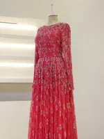 Luxurious red dress with intricate sequin embellishments, long sleeves, and flowing skirt, perfect for special occasions or parties.