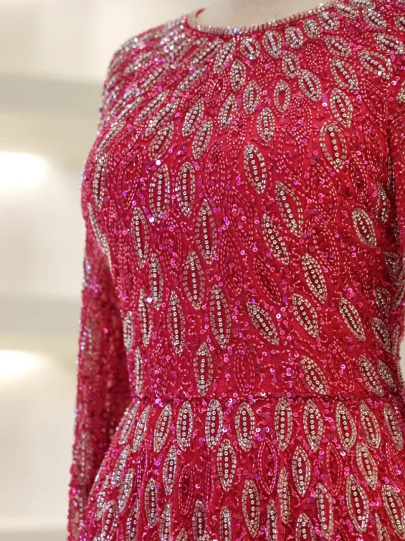 Vibrant red dress decorated with intricate silver and pink sequins, creating a luxurious and eye-catching pattern perfect for special occasions or celebrations.