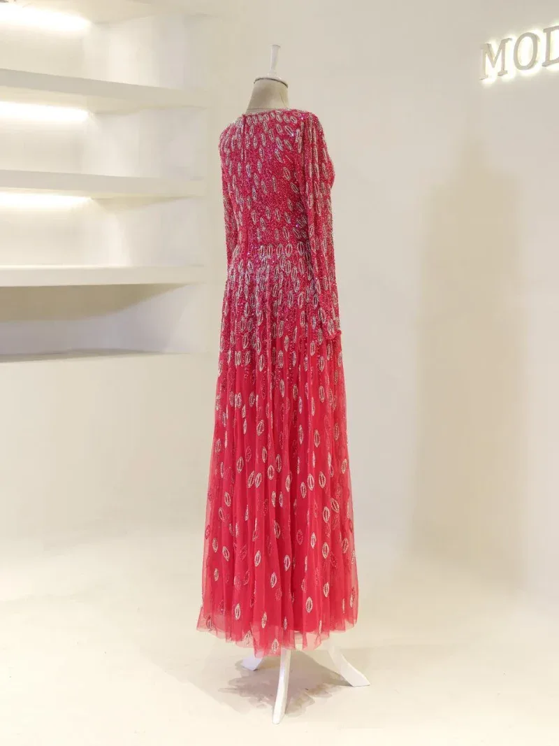 Gorgeous red evening gown featuring intricate beadwork and a flowing tulle skirt, perfect for formal events and special occasions. Crafted with high-quality materials for a luxurious look.