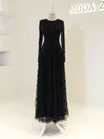 A stunning black evening gown featuring intricate sequins, long sleeves, and a flowing tulle skirt perfect for formal events and special occasions.