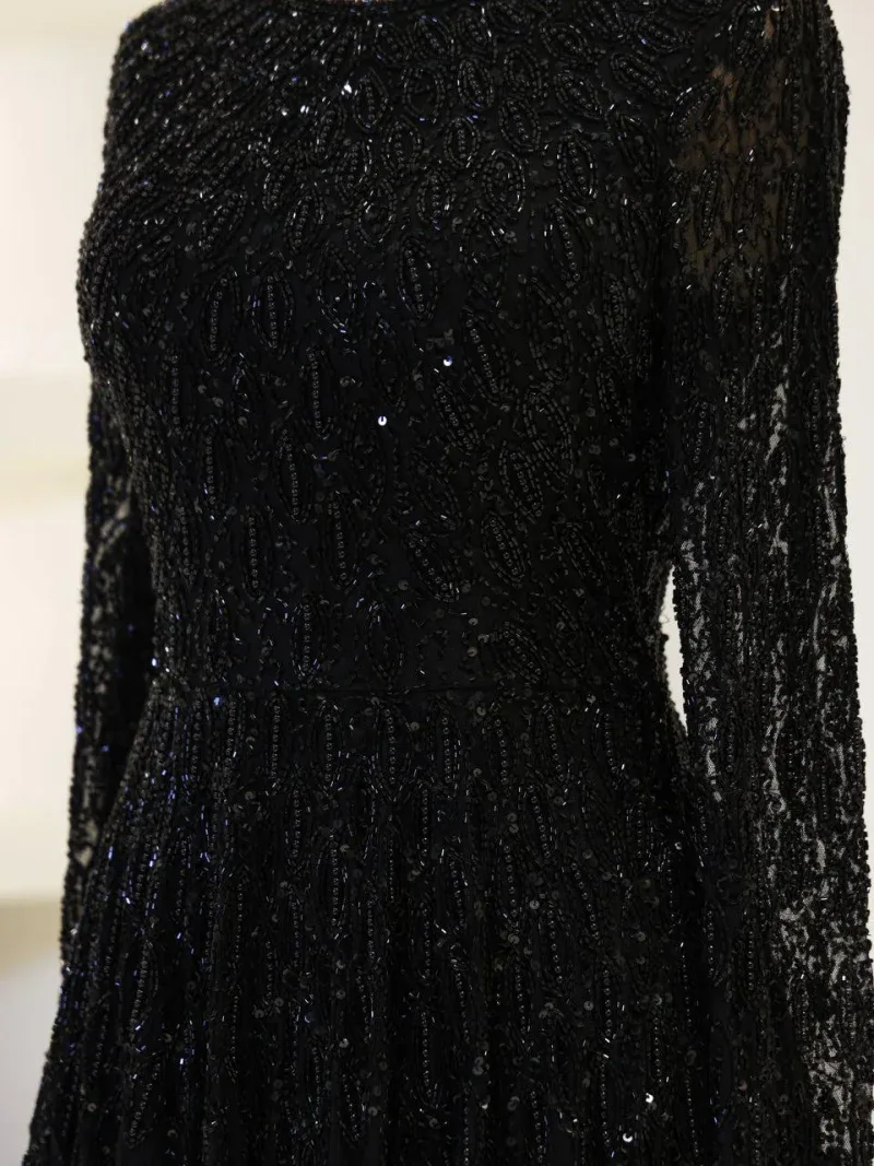 Glamorous black dress adorned with intricate beadwork and sequins, perfect for formal occasions and parties, showcasing detailed craftsmanship and luxurious style.