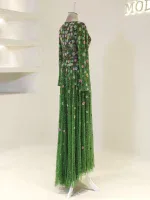 A beautiful green floral dress displayed on a mannequin, emphasizing Turkish fashion craftsmanship with detailed embroidery and elegant flowy fabric, ideal for festive or formal events.