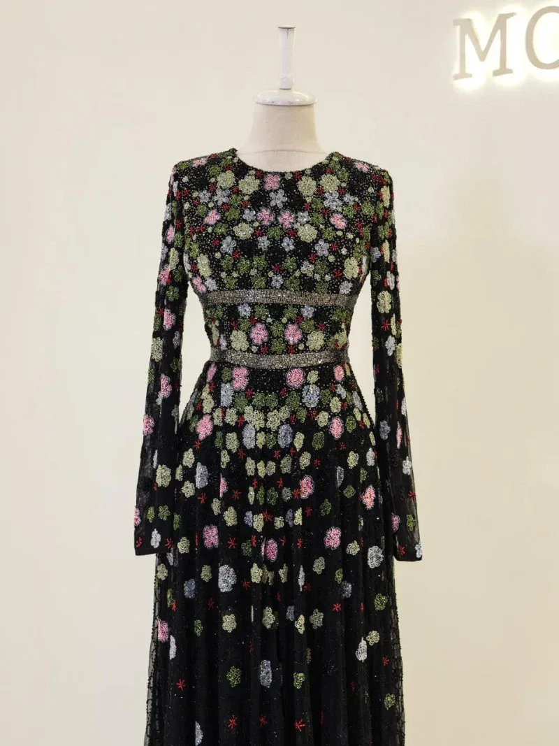 Stunning long-sleeve floral dress featuring intricate embroidery on black fabric, perfect for special occasions and fashionable events.