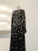 Stunning black dress with multicolored floral embroidery, long sleeves, and a flowing skirt perfect for special occasions or evening wear.