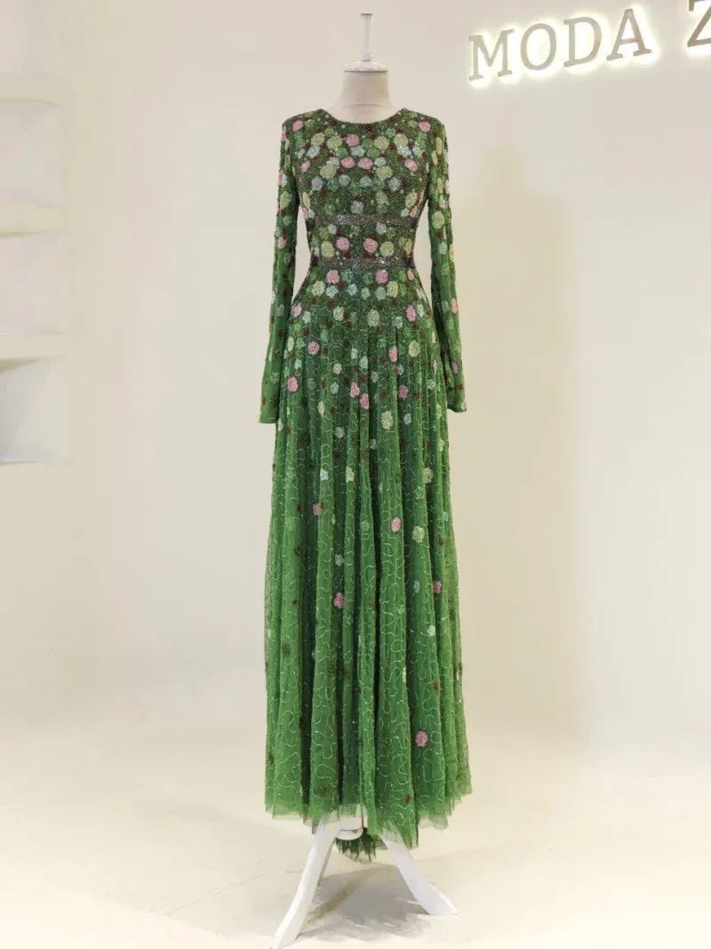 A stunning green floral maxi dress with intricate embroidery, long sleeves, and a flowing skirt, perfect for special occasions and elegant events.