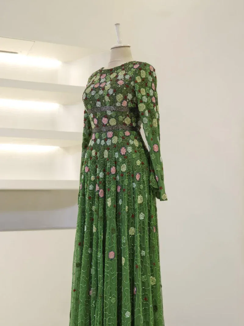 Vibrant green dress featuring intricate floral embroidery, long sleeves, and a flowing skirt, perfect for special occasions and stylish outings.