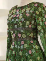 Intricate green floral beaded dress with pink and red accents, featuring detailed embroidery and shimmering embellishments, perfect for special occasions and cultural celebrations.