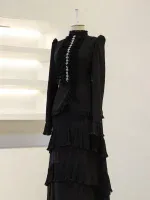 Stylish black dress featuring multiple ruffled layers and intricate jewelry embellishments on the front, perfect for formal occasions or evening events.