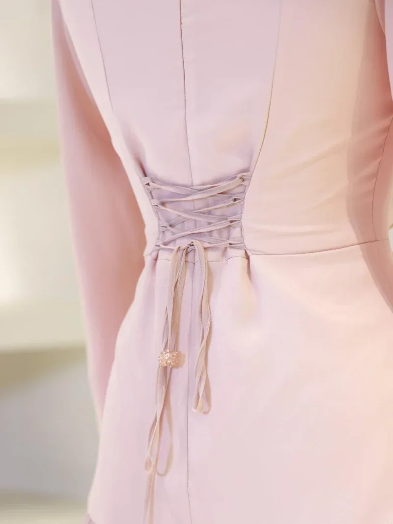 Luxurious pink dress with stylish lace-up details accentuating the waist for a flattering fit. Made from smooth, high-quality fabric, perfect for formal occasions or special events.