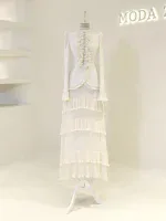 Stylish ivory dress with layered ruffles and pleats, perfect for formal occasions or fashion-forward events. Features long sleeves and intricate detailing, available for quick shipping from Turkey.