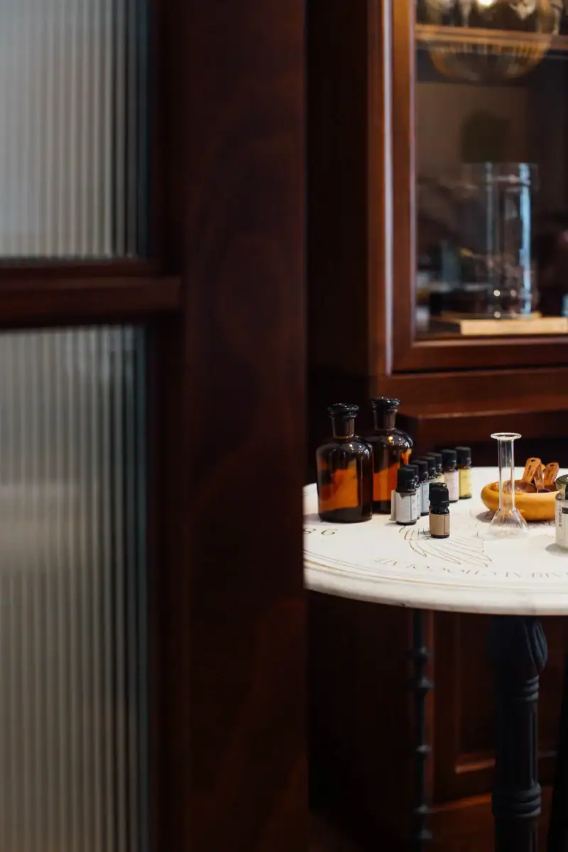 1. Aromatherapy essential oils and glass bottles on a white table in a cozy wooden room, perfect for wellness and relaxation.