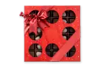 Deluxe holiday chocolate box with festive red ribbon and berry decoration, featuring assorted chocolates and truffles from Harem Chocolate, perfect for gift-giving during festivities.